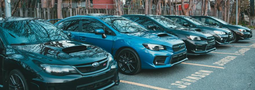 Small diesel cars from different brands like Subaru and Mercedes in a parking lot